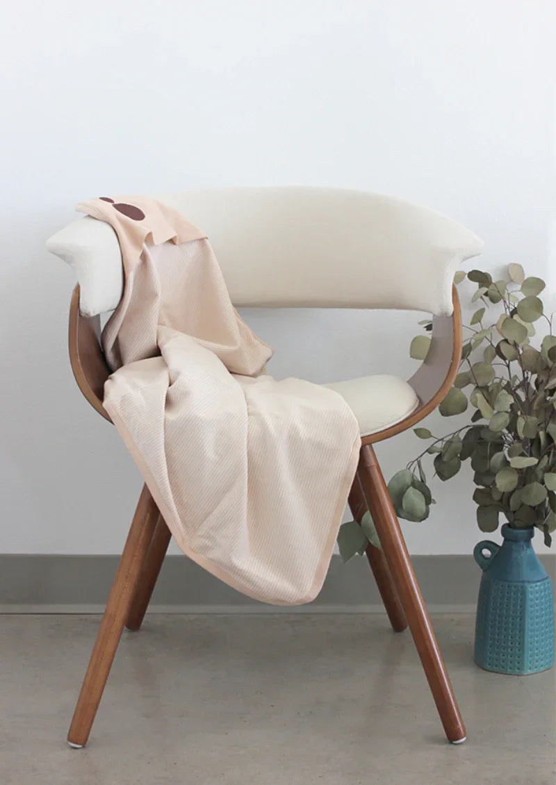 Cream Belly Armor organic cotton belly blanket draped over a chair