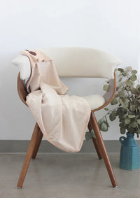 Cream Belly Armor organic cotton belly blanket draped over a chair