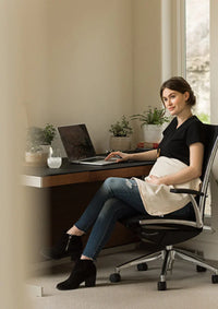 Pregnant woman using a laptop with a Belly Armor organic belly blanket on her lap