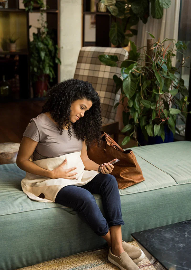 Pregnant woman sitting beside her child with an organic Belly Armor blanket on her lap