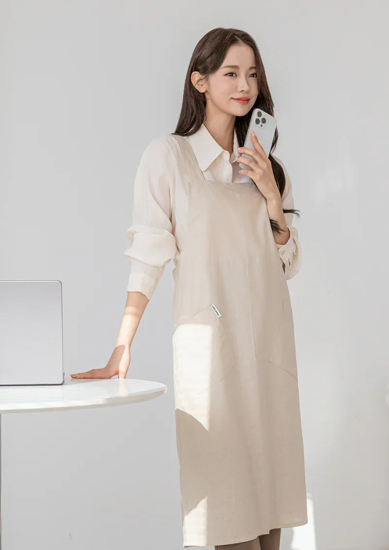 Woman wearing a beige Belly Armor linen EMF protection apron while using her phone