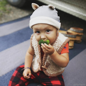 Baby eating while wearing mouse baby hat