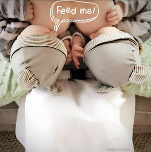 Breastfeeding twins wearing baby hats