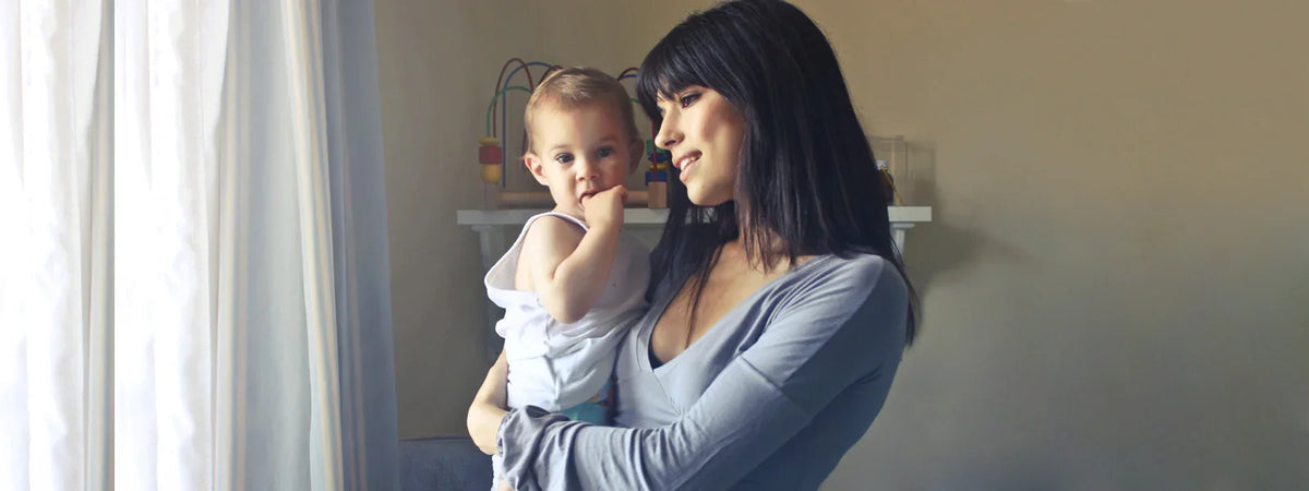 Mother holding her baby in a softly lit nursery