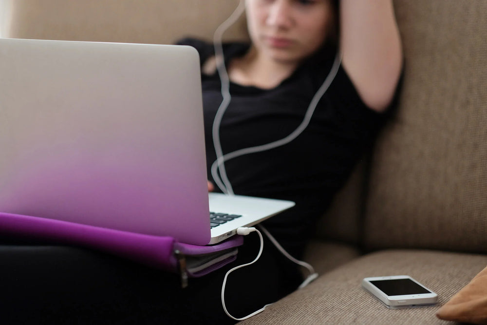 Woman using a laptop while relaxing on a sofa