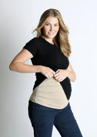 Woman lifting her shirt to show a beige Belly Armor adjustable EMF belly band